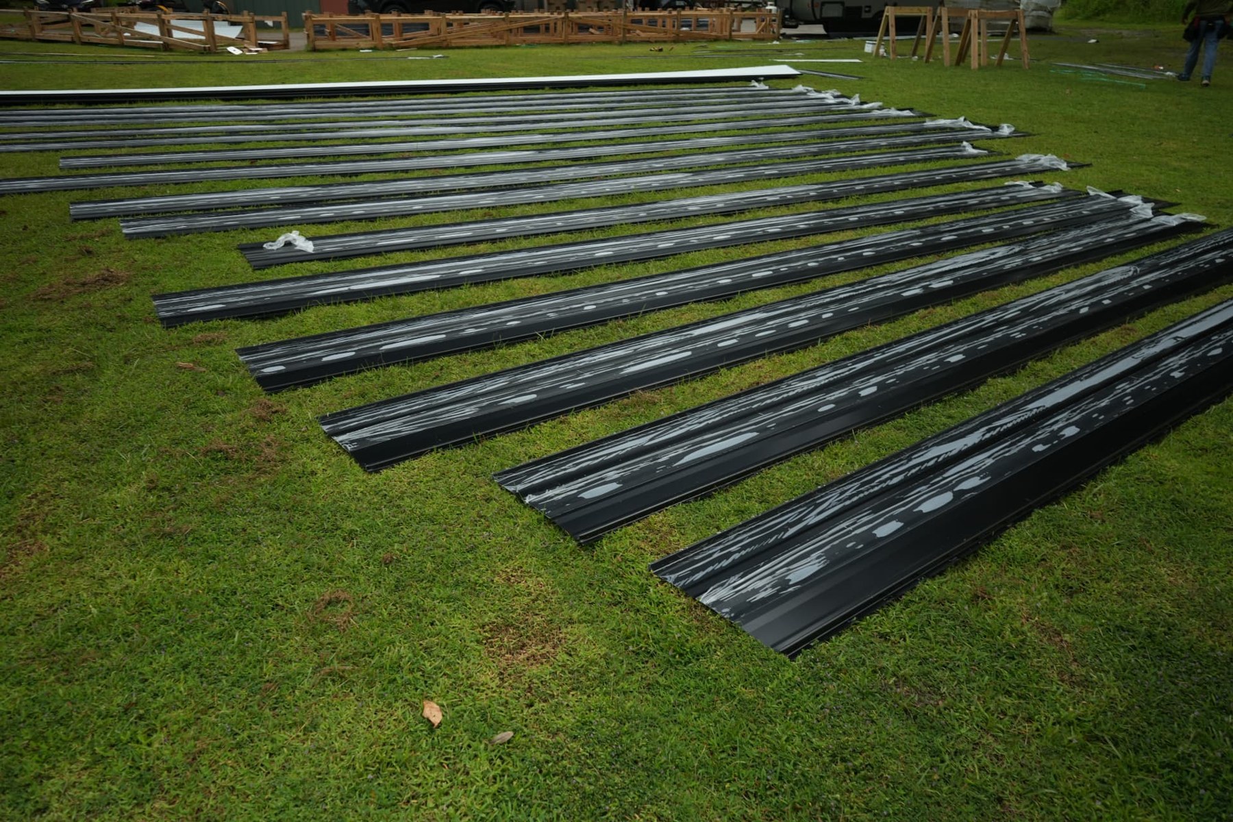 Close view of metal roofing panels with protective film staged at the Kissimmee job site