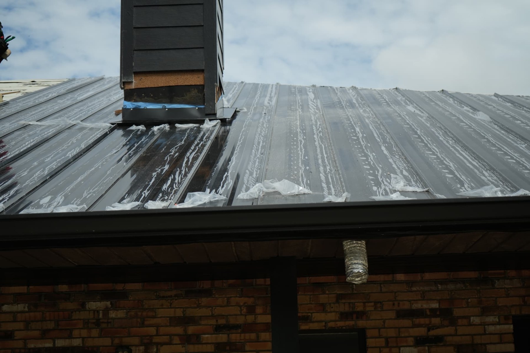 Metal roof panels and flashing around a chimney on the Kissimmee small commercial building