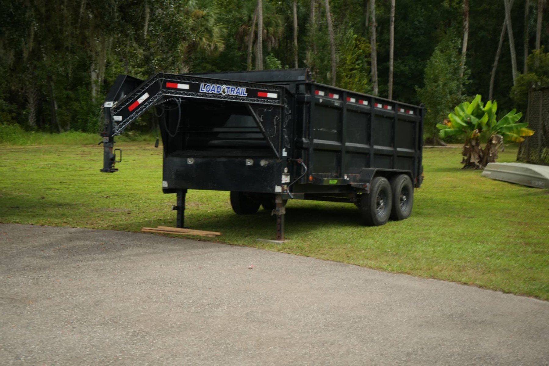Black dump trailer at the small commercial metal roofing job site in Kissimmee, Florida